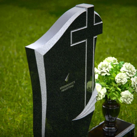 Traditional granite headstones with cross design and flower vase.