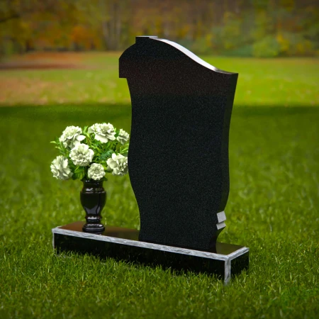 Traditional granite headstones with cross design and flower vase.