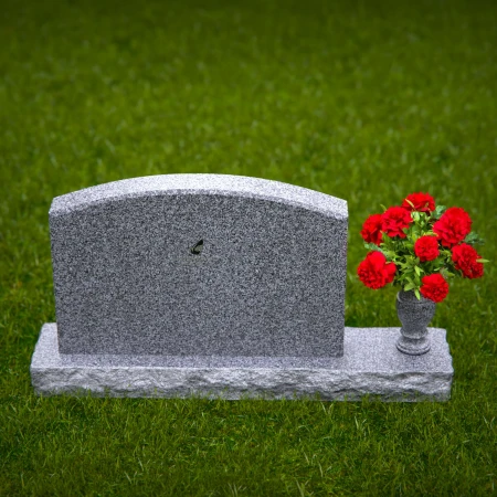 Waved granite headstones featuring floral vase tribute.