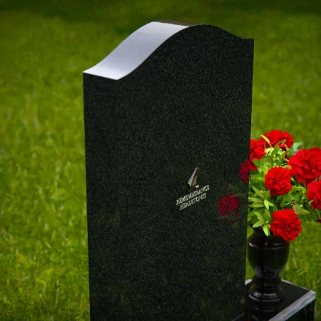 Classic granite headstones with arched top and flower vase.