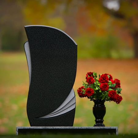 Modern headstones with artistic curves and a matching floral vase.