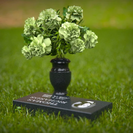 Compact headstones featuring photo inlays and floral vases for memorials.
