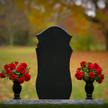 Unique shaped headstones with dual flower vases for memorial tribute.