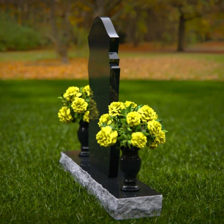 Unique shaped headstones with dual flower vases for memorial tribute.