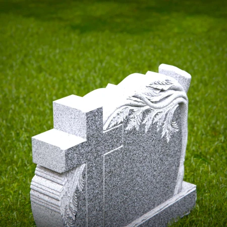 A carved cross and branching life tree define these headstone near me