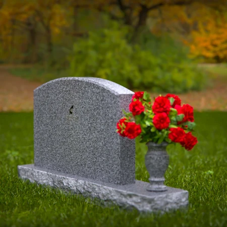 Waved granite headstones featuring floral vase tribute.