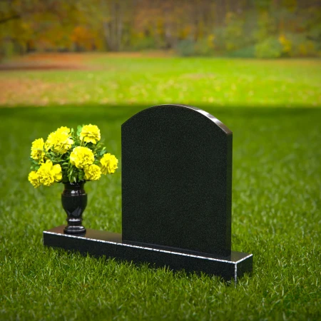 Classic arched granite headstones with polished vase tribute.