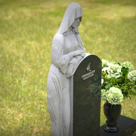 Praying angel sculpture resting beside floral tribute on classic headstones.