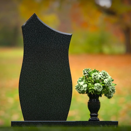 Modern contoured granite headstones with single flower vase.