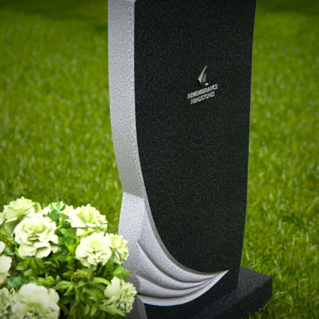 Artistic headstones with unique curved design and flower vase.