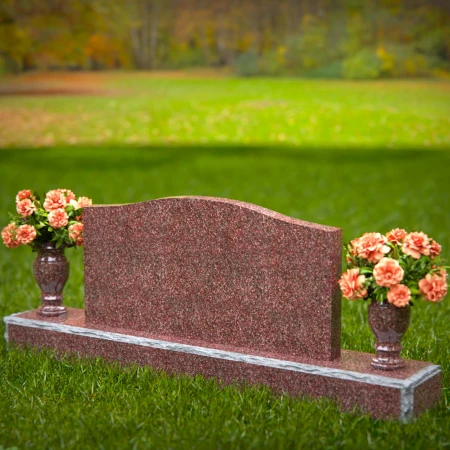 Artistic wave-top headstones with twin floral vases.