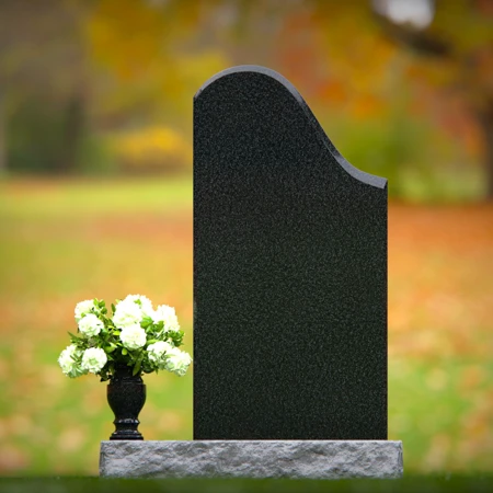 Elegant sloped headstones with floral vase for timeless tribute.