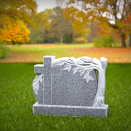 A carved cross and branching life tree define these headstone near me