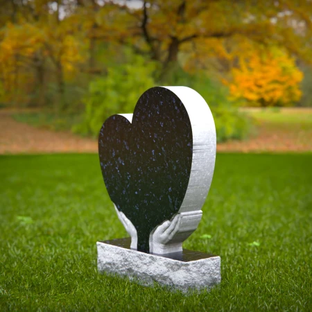 Comforting headstones with sculpted hands gently cupping heart