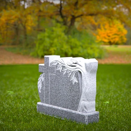 A carved cross and branching life tree define these headstone near me