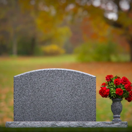 Waved granite headstones featuring floral vase tribute.