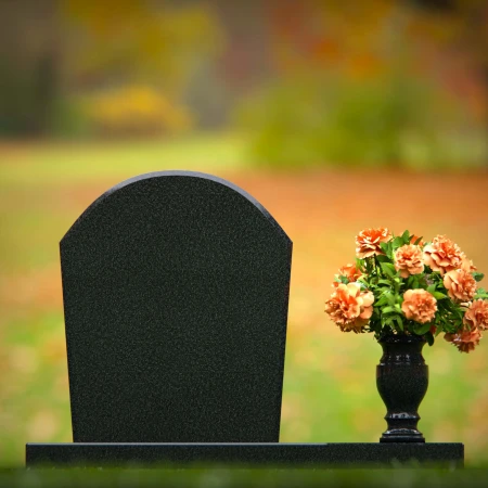 Classic arched granite headstones with single flower vase tribute.