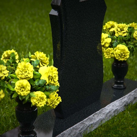 Unique shaped headstones with dual flower vases for memorial tribute.