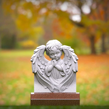 Reflective child tombstones carved with kneeling cherub angel