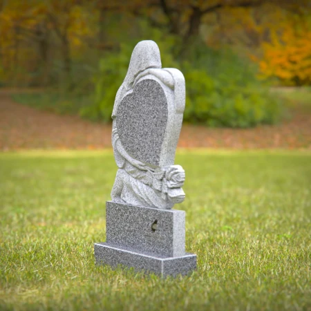 Heart-shaped gray granite headstone with angel design — a touching memorial tribute.
