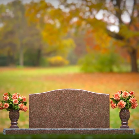 Artistic wave-top headstones with twin floral vases.