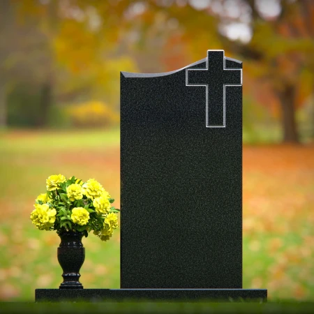 Upright granite headstones with cross design and flower vase.