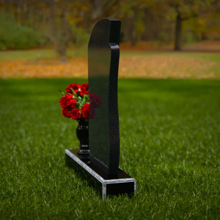 Modern headstones with artistic curves and a matching floral vase.