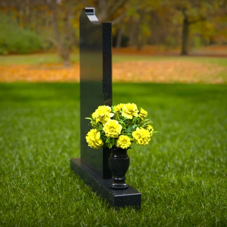 Upright granite headstones with cross design and flower vase.