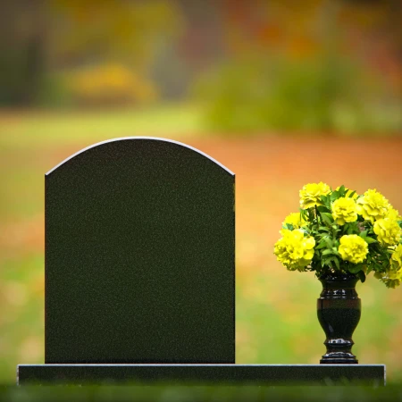 Classic arched granite headstones with polished vase tribute.