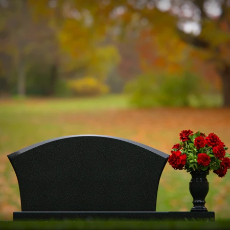 Contoured granite headstones with single flower vase for tribute.